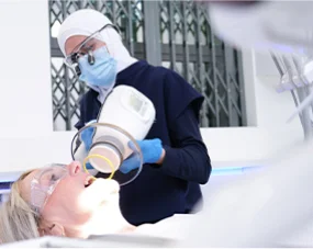 A dental professional at Leeds Dental Implant & Cosmetic Clinic performing an advanced digital X-ray scan on a patient.