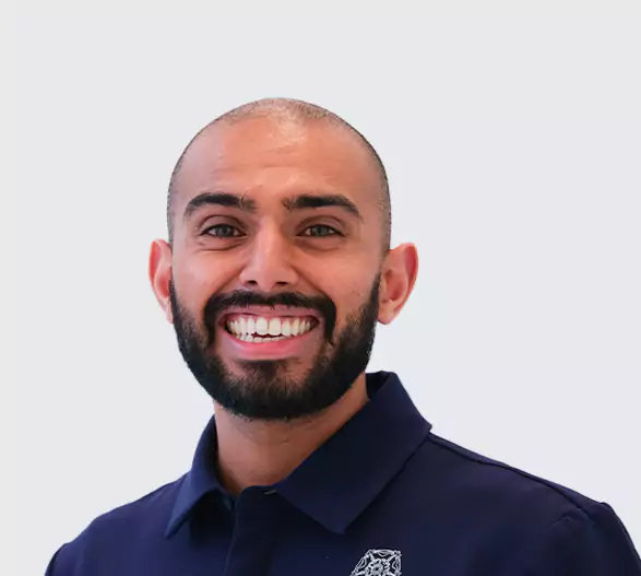 Smiling dental professional in navy uniform at Leeds Dental Clinic.