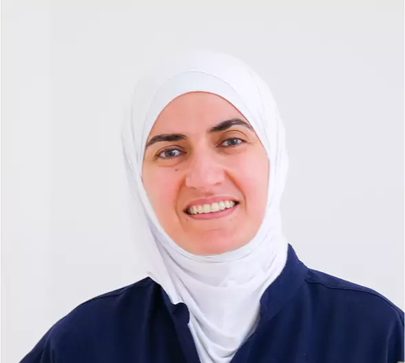 Smiling female dental professional in navy scrubs at Leeds Dental Clinic.