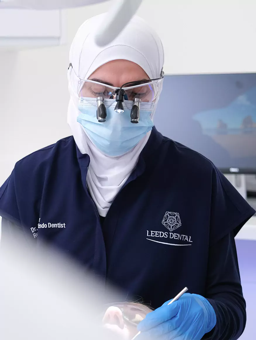 Female dentist wearing magnifying loupes performing a dental procedure at Leeds Dental Clinic.