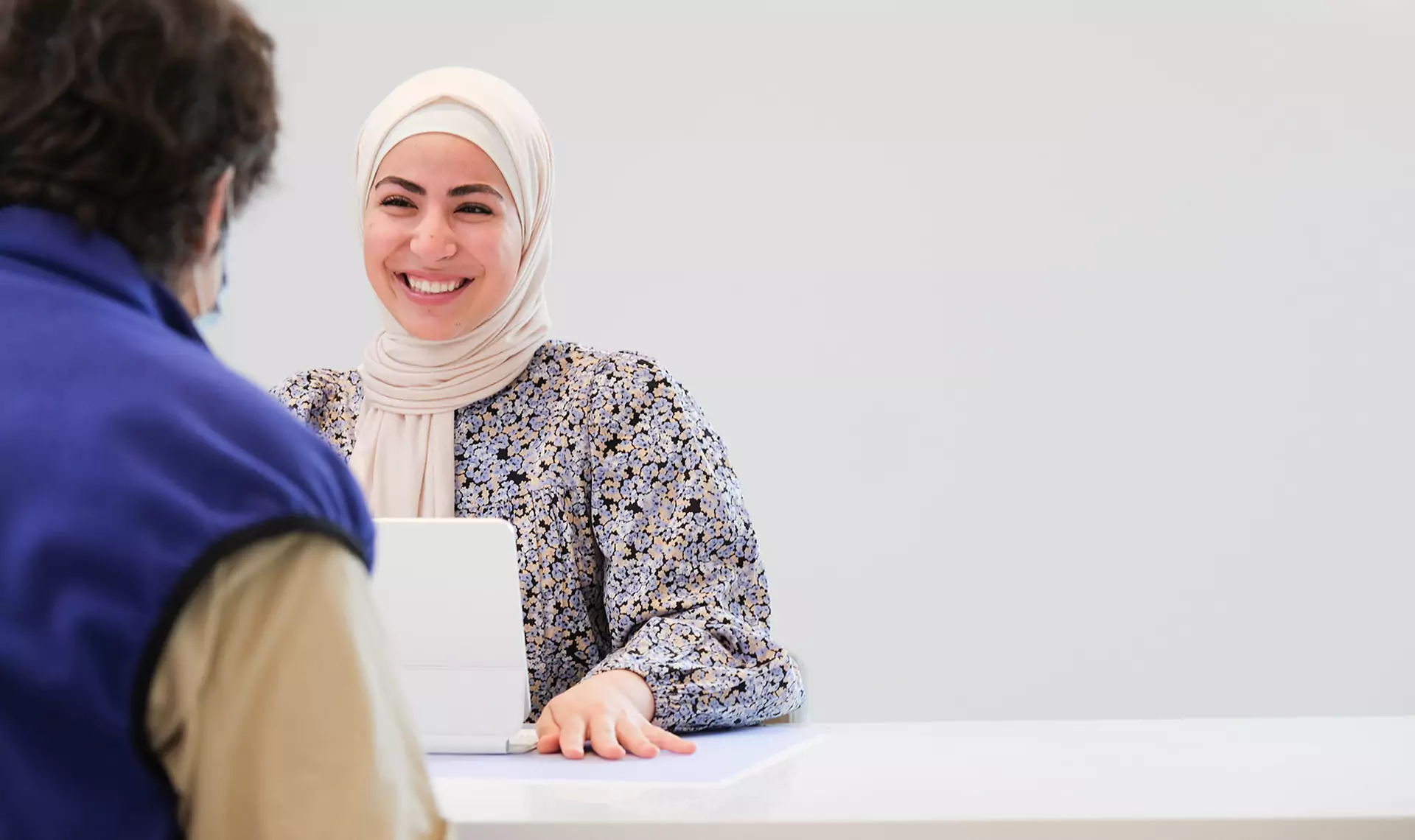 Smiling receptionist assisting a patient at Leeds Dental Clinic.